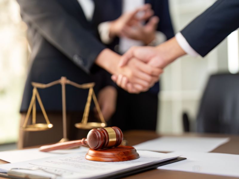 Lawyers shaking hands, agreeing on the definition of general damages, special damages, and general damages vs special damages. 