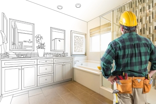A contractor looks at a home's bathroom and contemplates how to remodel it. This photo is for the article titled, "How to Safeguard Your Home from Unlicensed General Contractors."