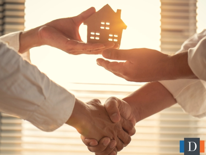 A man and a woman holding a small figure of a home to represent estate planning in Wake Forest, NC.