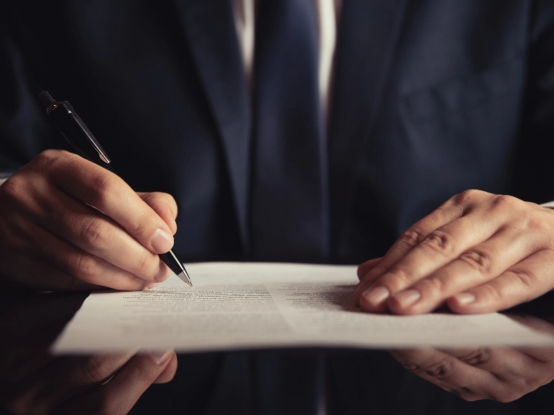 A Wake Forest wills lawyer signs a wills.